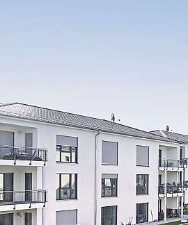 Weiße Mehrfamilienhäuser mit Balkonen und geschlossenem Himmel