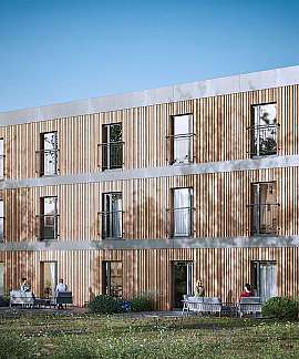 Dreigeschossiges Gebäude mit Holzfassade und Balkonen in einer grünen Gartenlandschaft.